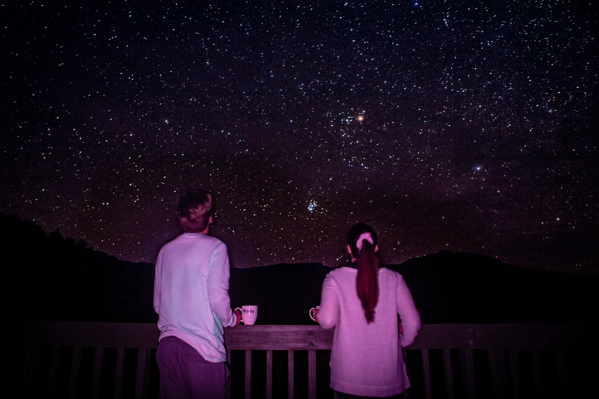 man and woman standing in front of galaxy